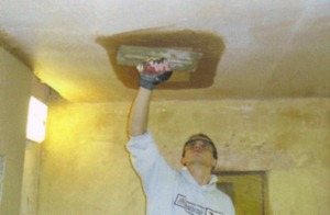 James repairing a hole in a ceiling